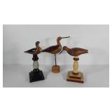 Wooden shore bird statues, one is missing beak