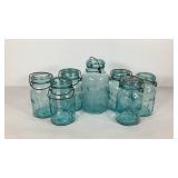 Seven Atlas EZ Seal canning jars, some with lids