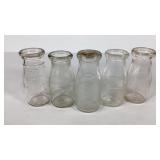 Five half pint milk bottles