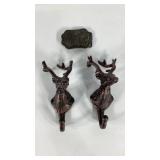 Two metal stag coat hooks and a belt buckle