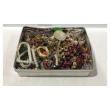 Tin of costume jewelry