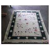 Green and white area rug with flower design,