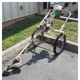 The green machine weedeater on rolling cart