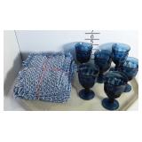 Six blue stemmed cups and eight blue woven napkins