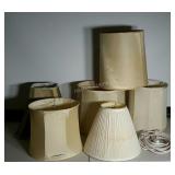 Six assorted lamp shades and two extension cords.