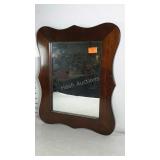 Small hanging mirror in solid wood frame.