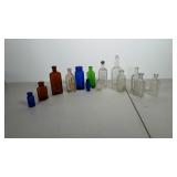 Lot of glass medicine bottles. Most have writing