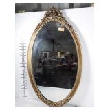 Heavy oval gold framed mirror.  Frame and mirror