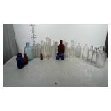 Lot of glass bottles. Nearly all have wording on
