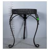 Metal plant stand with leaf detail on legs.
