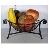 Fruit basket filled with oversized ceramic fruit.