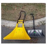Two snow shovels, yellow one has damage on corner
