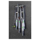 Two pairs of crutches and two golf clubs