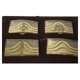Four Jostens commemorative belt buckles on