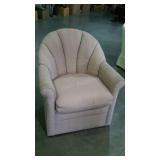 Upholstered chair with scalloped back.