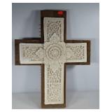 Ornate stone cross mounted on rustic wood base,