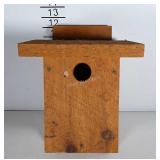 Bird house made of rough wood.