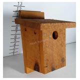 Bird house made of rough wood.