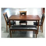 Dining table with three chairs and a bench. Shows