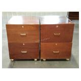 Two wooden two-drawer file cabinets on wheels. No