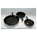 Three graduated cast iron skillets, marked