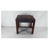 Small upholstered footstool, small tear on