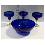 3 blue colored margarita glasses and a blue glass