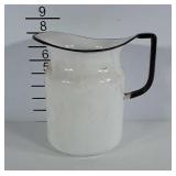 White enamel pitcher with black trim.
