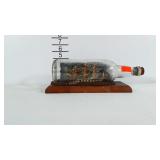 Ship in a bottle on wooden base.