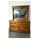Laminated seven drawer dresser with mirrored top.