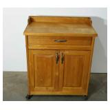 Rolling kitchen cart with cutting board top.