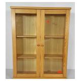 Wooden cabinet with glass panel doors. Front of
