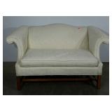 Camelback settee in an ivory brocade. North
