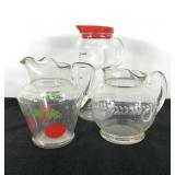 Three juice pitchers, includes etched and
