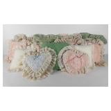 Thirteen throw pillows, most are lace or ruffle