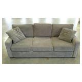 Grey three cushion sofa. Includes matching throw