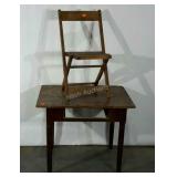 Rustic table missing a drawer and a folding chair