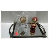Two small clocks and a mirrored tray, one egg