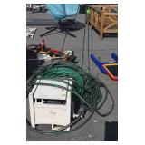 Suncast hose reel, several garden hoses, flower