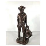 Bronzed cowboy and saddle statue by Austin
