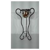 Metal plant stand with glass bowl of potpourri