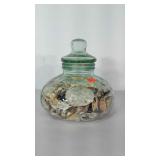 Green tinted glass canister with lid, full of sea
