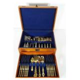 Gold toned flatware in chest. Enough spoons,