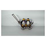 Plush penguin toys in bent twig cart. Cart has