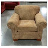 Upholstered chair with rolled armed in a suede