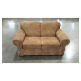 Upholstered loveseat with rolled armed in a suede