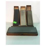 Four sharpening stones in wood boxes