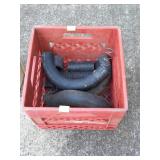 Red plastic milk crate with some radiator hose