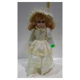 17" porcelain doll in yellow dress with doll stand