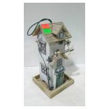 Birdfeeder in shape of tall house.